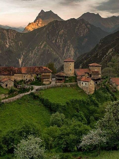 Pueblo de casas de piedra entre montañas y prados