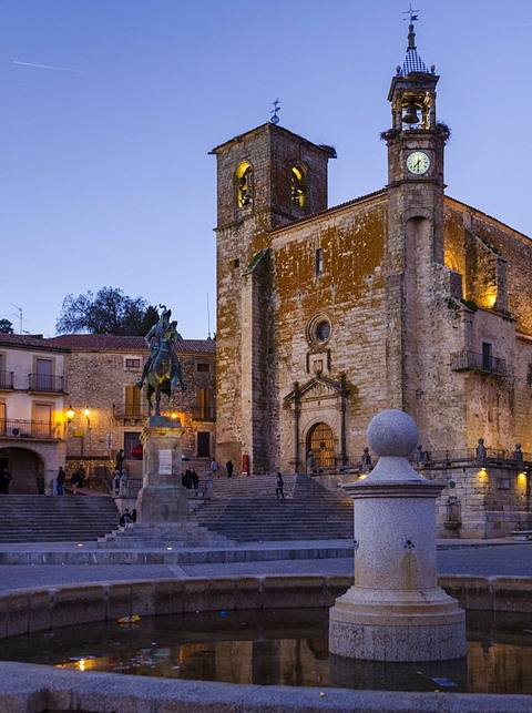 Plaza Mayor de Trujillo al anochecer, con la iglesia de San Martín y la estatua de Pizarro